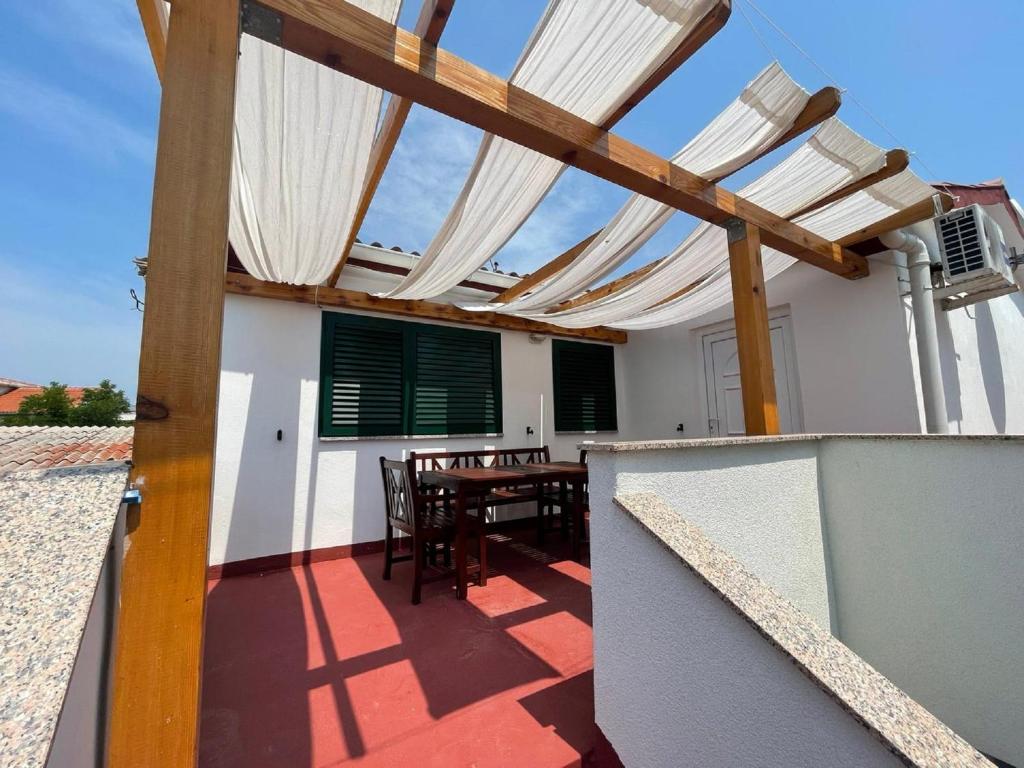 a patio with a wooden pergola and a table at MY DALMATIA - Beach Apartment Neno in Ražanac