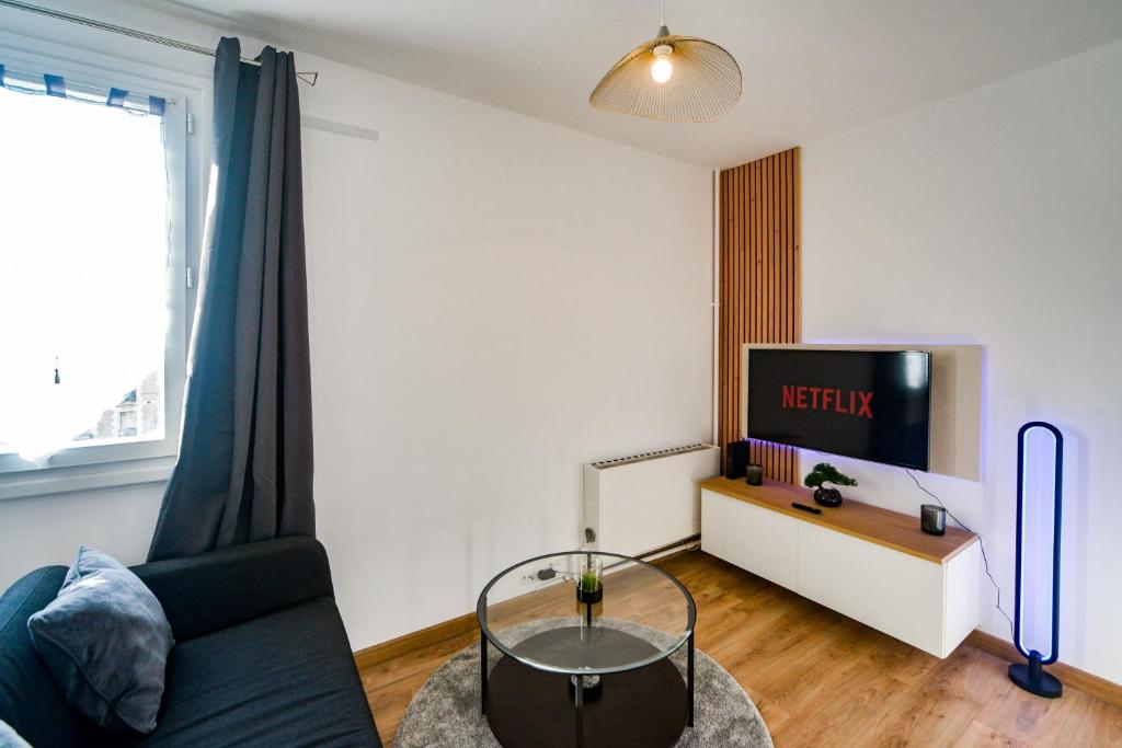 un salon avec un canapé et une télévision dans l'établissement Le Mirage Des Sables - Parking - Netflix, à Tours
