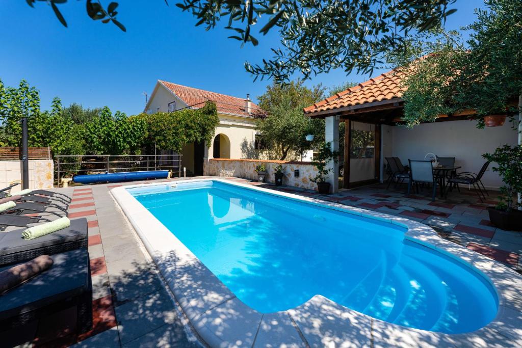 una piscina nel cortile di una casa di MY DALMATIA - Holiday home Olive Garden with private swimming pool a Lađevci
