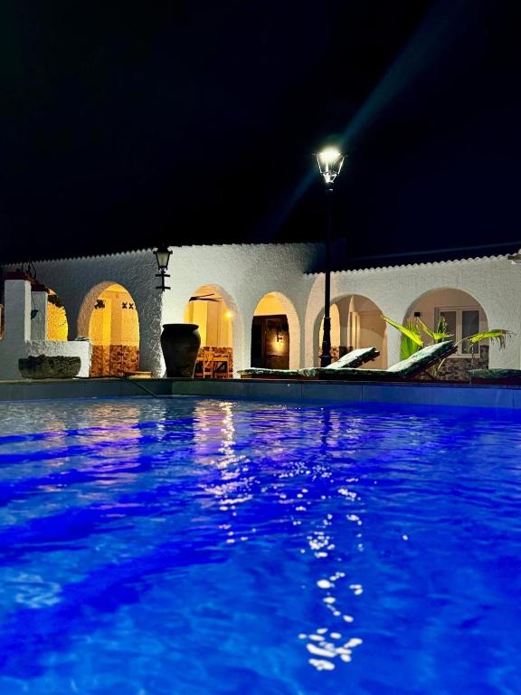 a swimming pool at night with blue water at Casa rural in Cabra