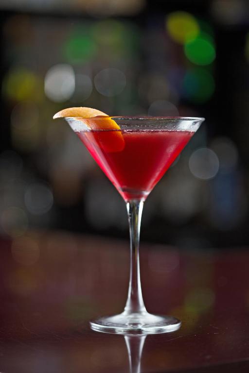 a red drink in a martini glass with an orange slice at Hotel Ruby in Spokane