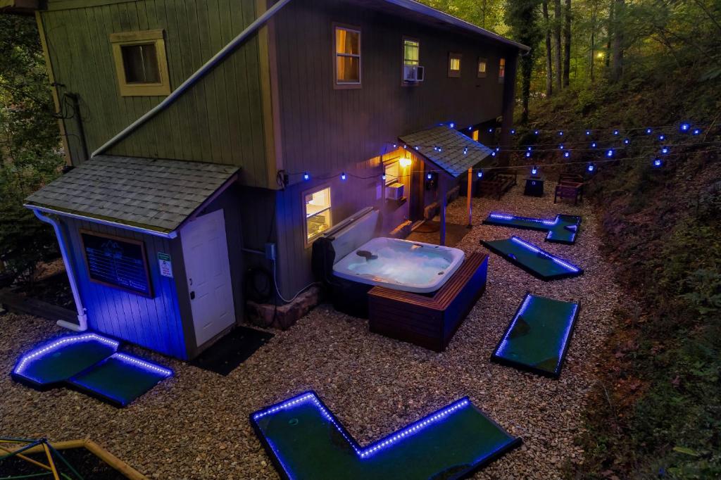 a backyard with a hot tub and a house with lights at Cozy Mountain Cabin, Sleeps 8, Mini Golf, Hot Tub, Coffee Bar! in Sevierville
