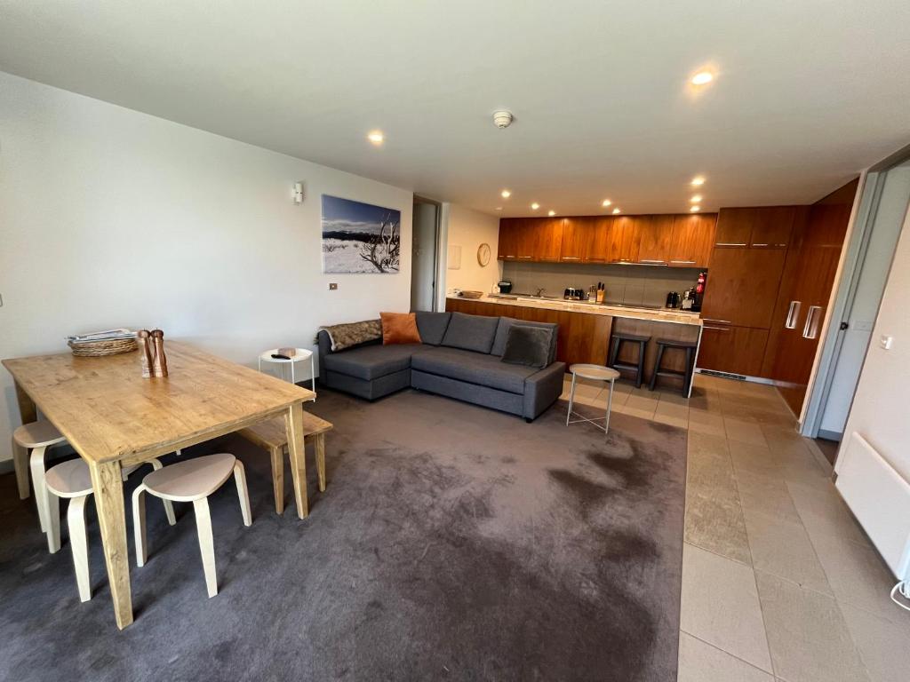 una sala de estar con un sofá y una mesa en Woodsmoke Seven, en Falls Creek