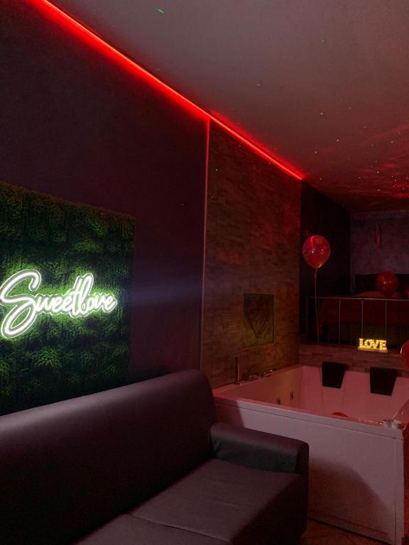 salon z kanapą i neonem w obiekcie Sweetlove Spa w mieście Terracina
