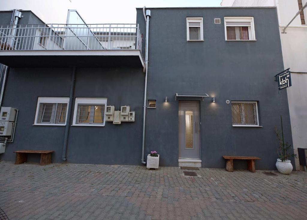 niebieski budynek z ławkami przed nim w obiekcie Katie's Blue House w mieście Wolos