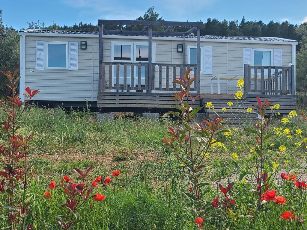 un mobile home dans un champ de fleurs dans l'établissement Camping Nysa Paziols, à Paziols