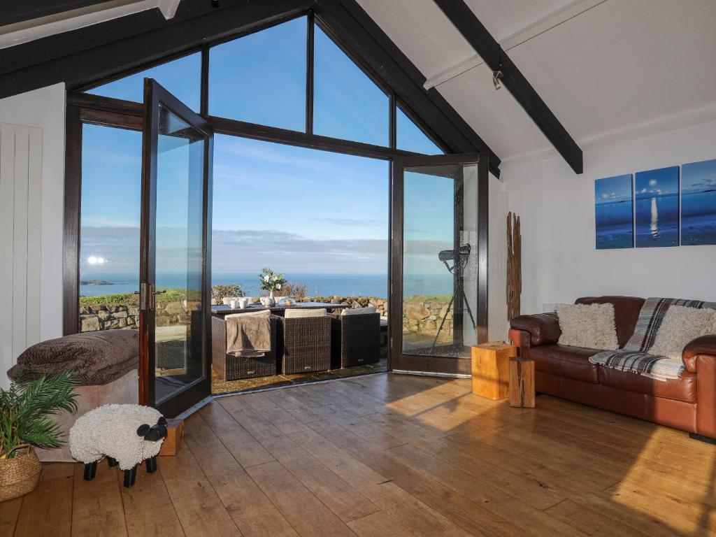 ein Wohnzimmer mit einer großen Glastür, in der ein Schaf sitzt in der Unterkunft Tai Ffolt in Pwllheli