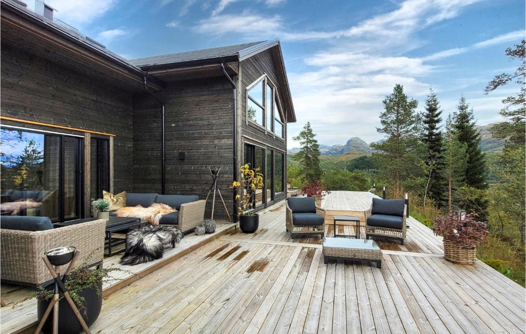 a deck with chairs and a table on a house at Awesome Home In Norheimsund With Sauna in Norheimsund