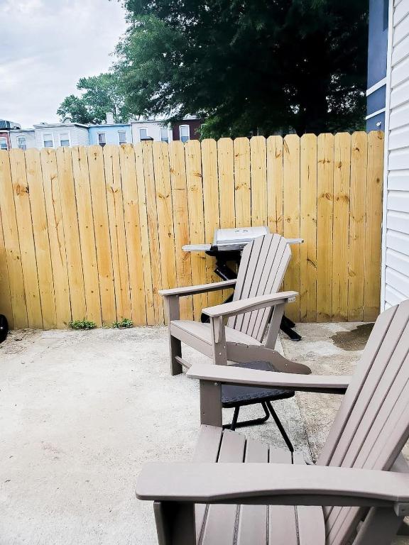two white chairs sitting next to a wooden fence at NoMA 3BR Townhome - UnionMarket H St Streetcar in Washington, D.C.