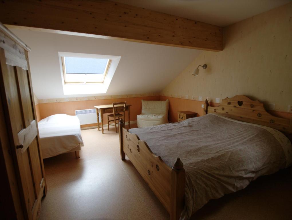 a bedroom with two beds and a table and a window at Auberge De La Charriole in Taintrux