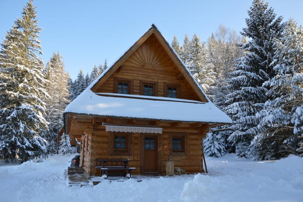 Cabaña de madera con nieve en el techo en Drevenica Zuberec en Zuberec