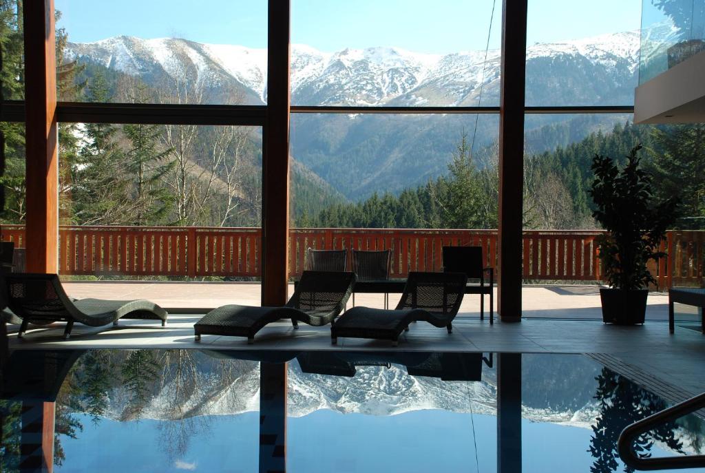 a room with a pool and a view of mountains at Hotel Rozsutec in Terchová