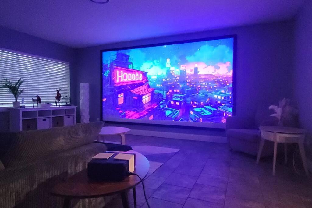 a living room with a large flat screen tv at Relaxing 3-Bedroom With 150 Inch Projector & Pool Table in Jacksonville