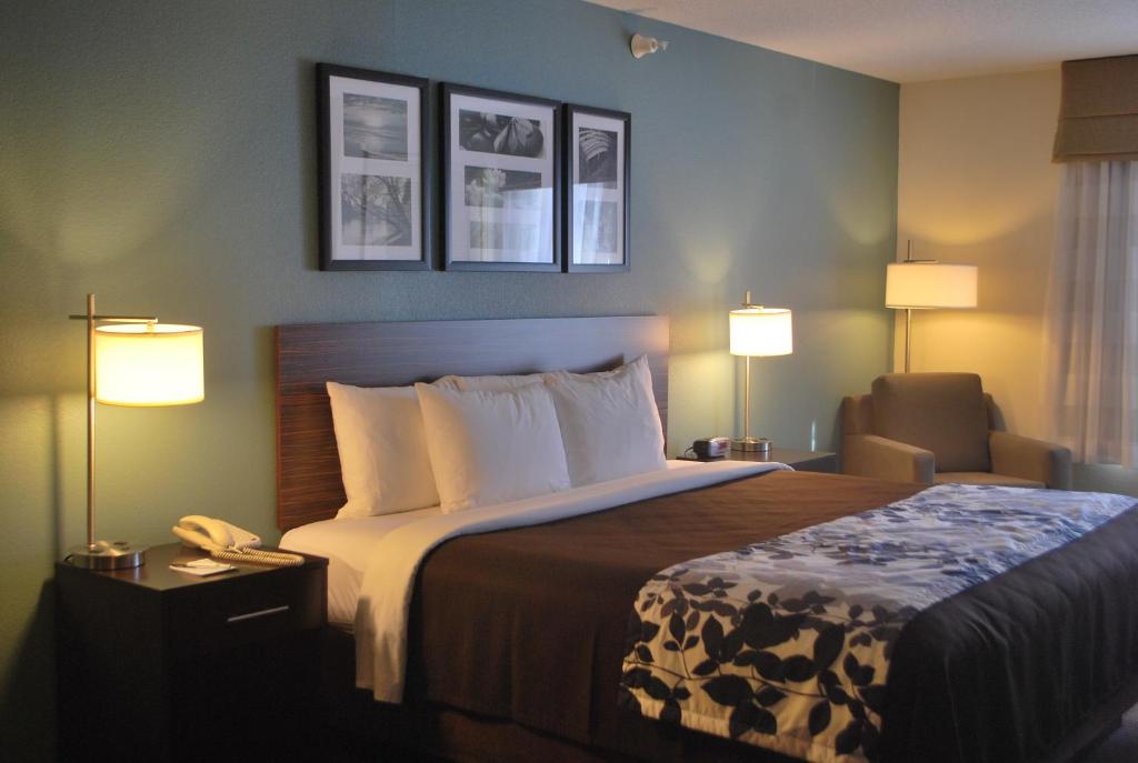 a hotel room with a bed with two lamps and a phone at Sleep Inn & Suites Clintwood in Clintwood