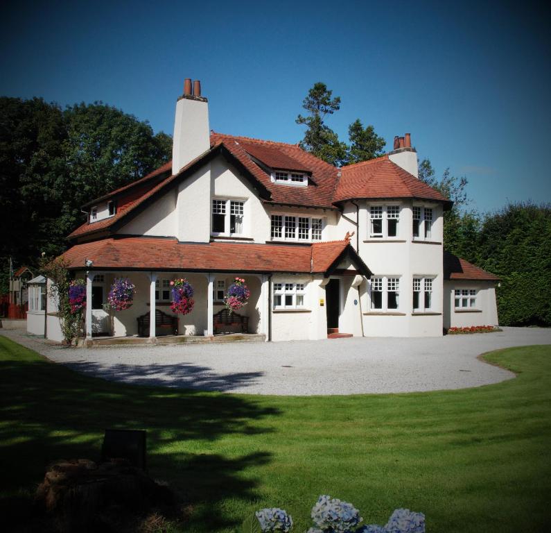 uma grande casa branca com um telhado vermelho em Rivendell em Dumfries