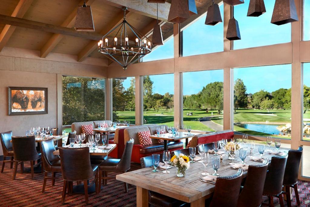 a dining room with tables and chairs and a large window at Temecula Creek Inn in Temecula