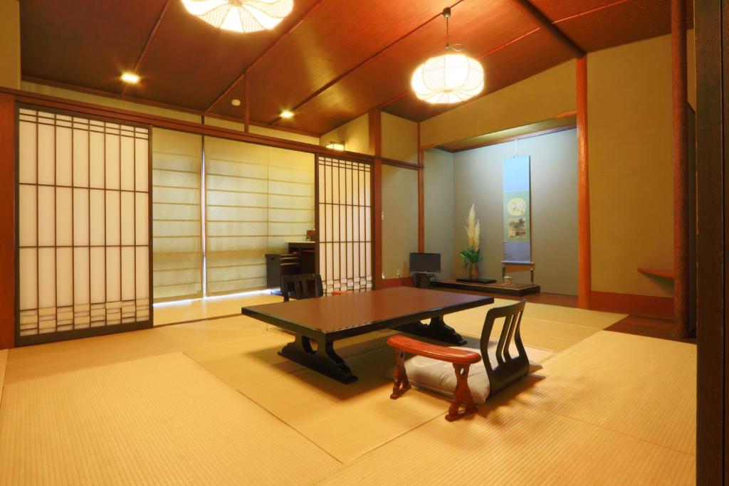 a room with a table and a chair in it at 割烹旅館小川荘 in Ōmiya