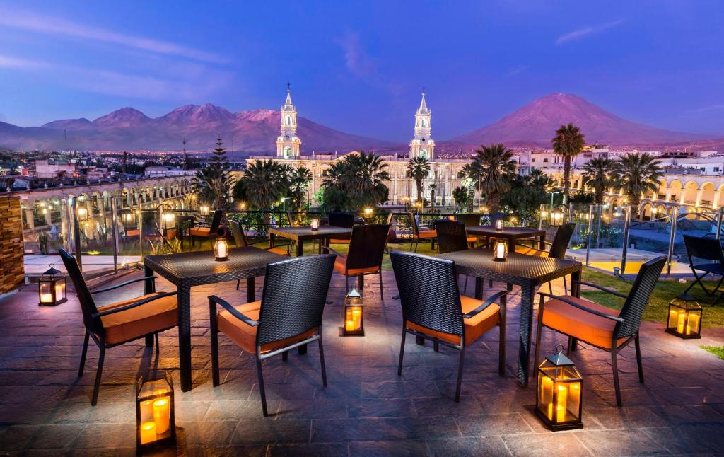 a patio with tables and chairs and a view of a city at Katari Hotel at Plaza de Armas in Arequipa