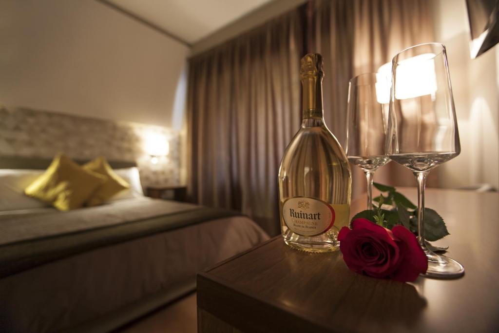 una habitación de hotel con una botella de vino y una copa en NG Guest House Roma San Pietro, en Roma