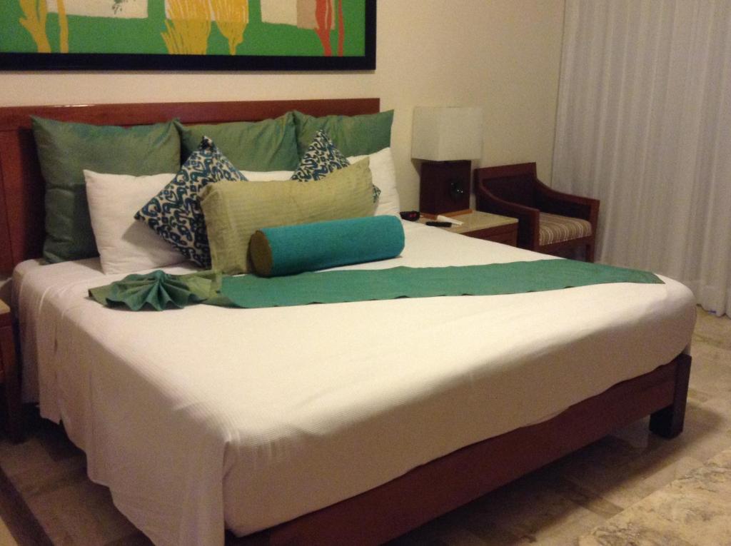 a bedroom with a large bed with pillows on it at Suites at Mayan Palace Vidanta Resort Riviera Maya in Playa del Carmen