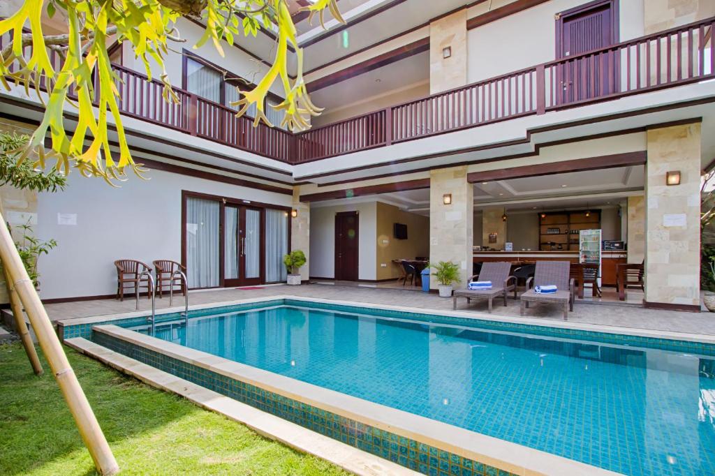 a swimming pool in front of a house at Amelle Villas & Residences Canggu in Canggu