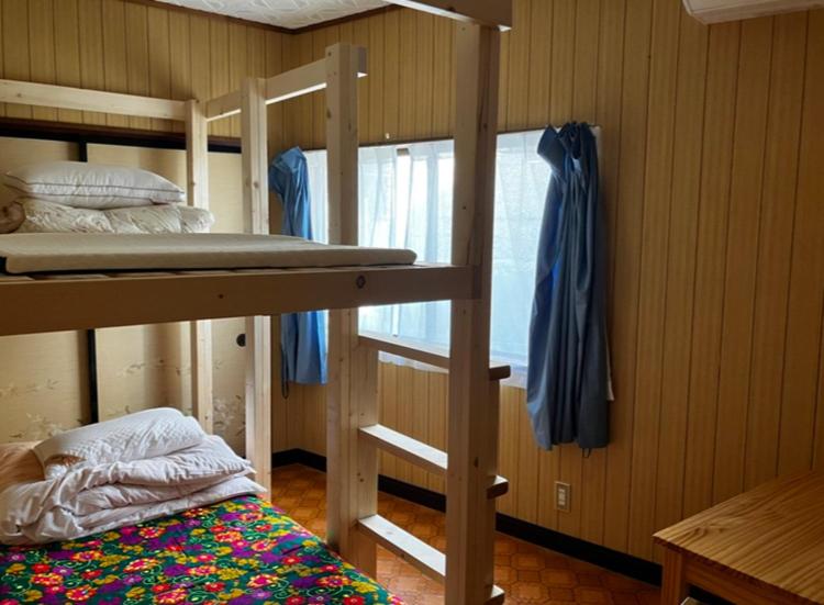 Postel nebo postele na pokoji v ubytování ゲストハウス黒島