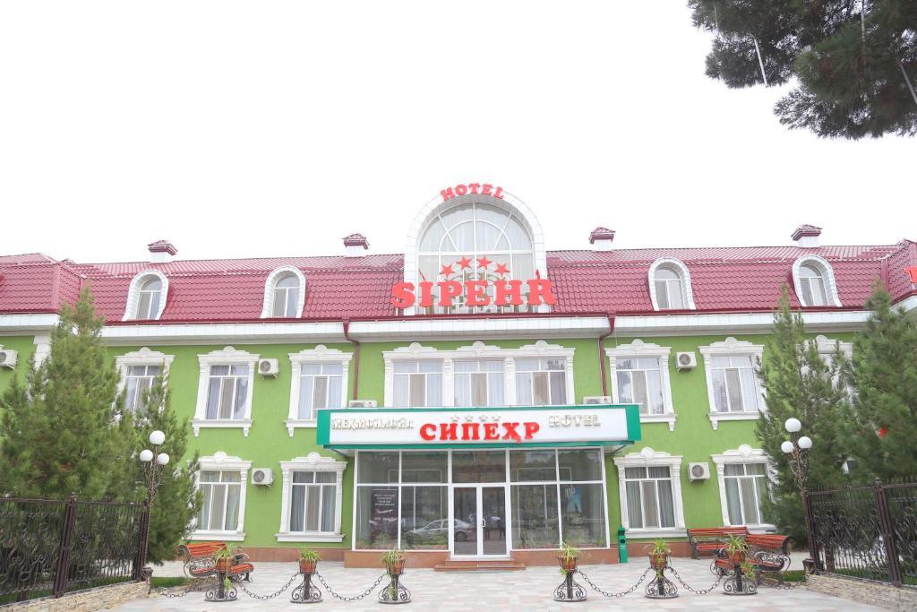 un gran edificio verde con un cartel delante en Sipehr Hotel, en Chkalovsk