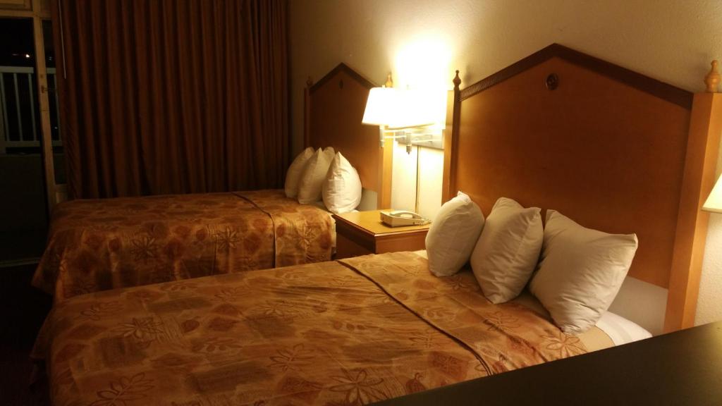 a hotel room with two beds with white pillows at Lotus by Hotel Inn - Hot Springs in Hot Springs