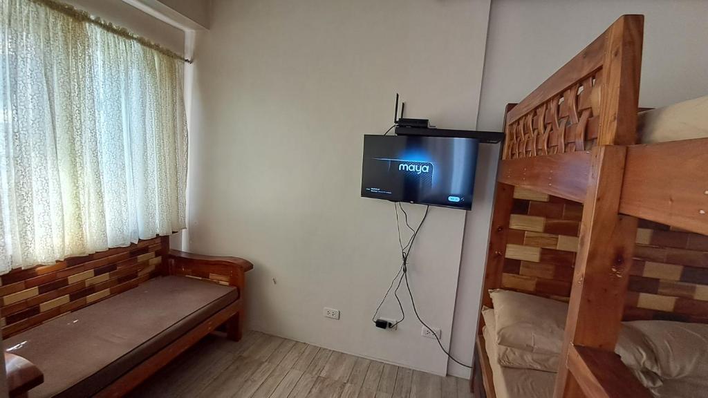 a bedroom with a bunk bed and a tv in a room at petite abode in Baguio