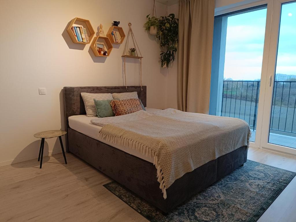 a bedroom with a bed and a large window at Cozy one-room apartment with garage and AC in Bratislava