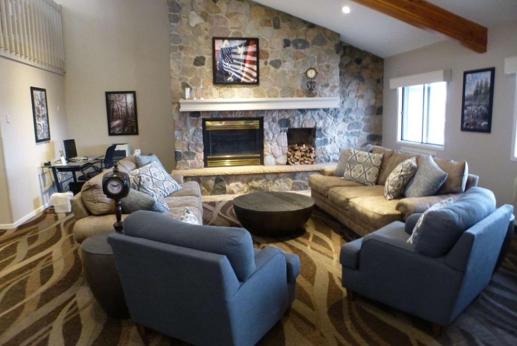 a living room with couches and a stone fireplace at AmericInn by Wyndham Mitchell in Mitchell