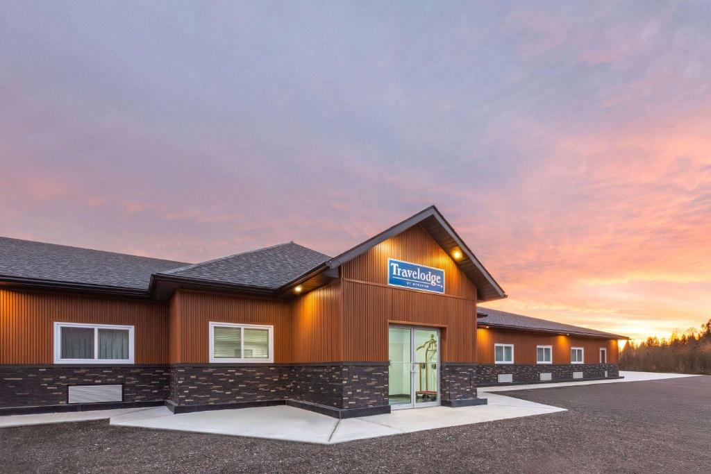 a building with a sign that reads hospital at Travelodge by Wyndham Cochrane Ontario in Cochrane