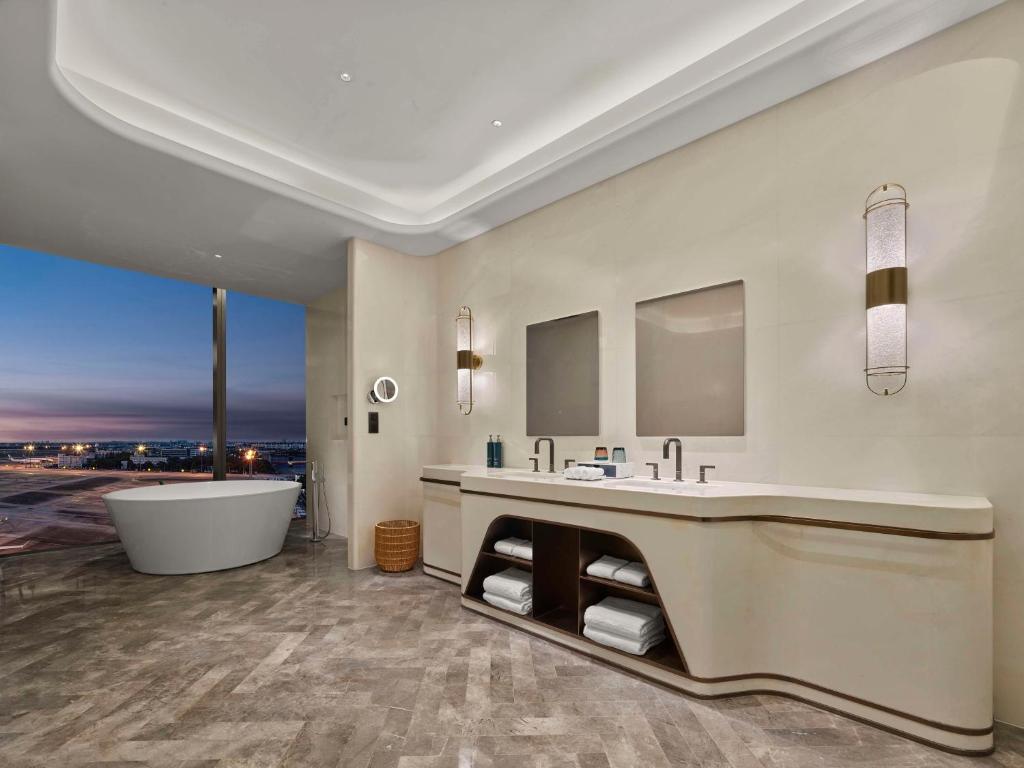 a bathroom with a tub and a large sink at Hilton Shanghai Hongqiao International Airport in Shanghai