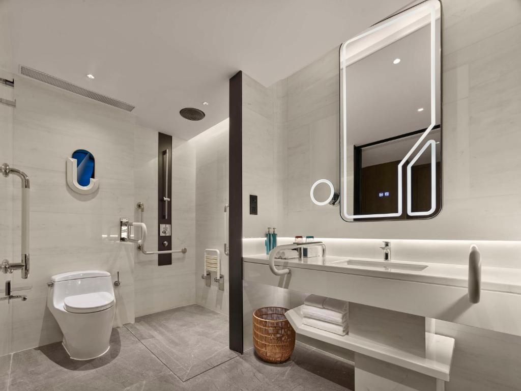 a bathroom with a toilet and a sink and a tub at Hilton Shanghai Hongqiao International Airport in Shanghai