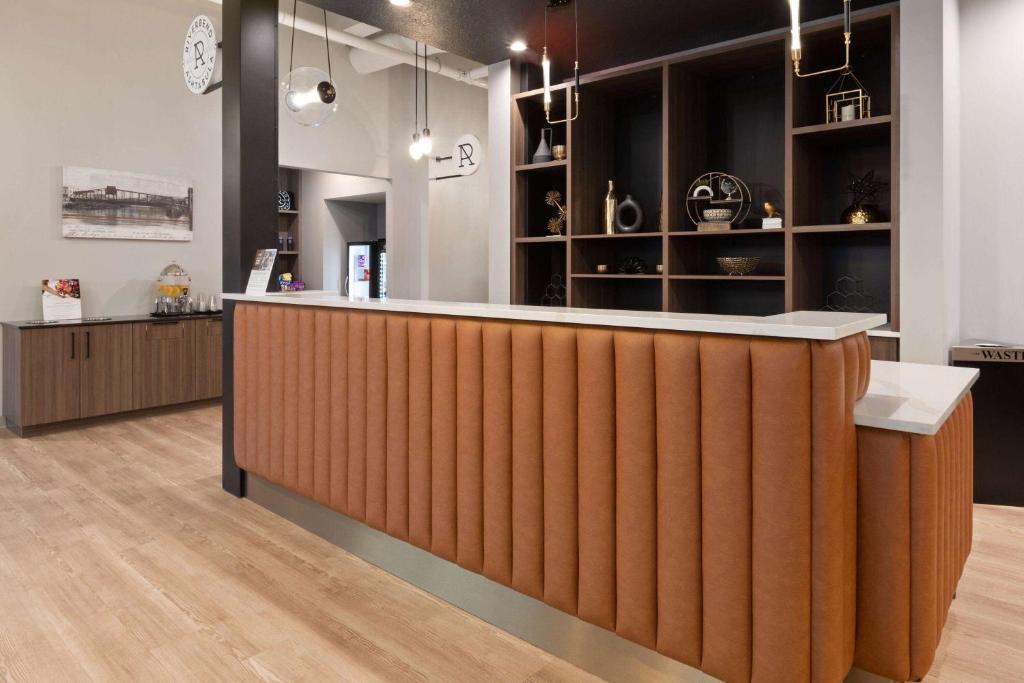 eine Lobby mit einer Holztheke und einer Bar in der Unterkunft Riverbend Hotel and Suites, Trademark Collection by Wyndham in Ashtabula