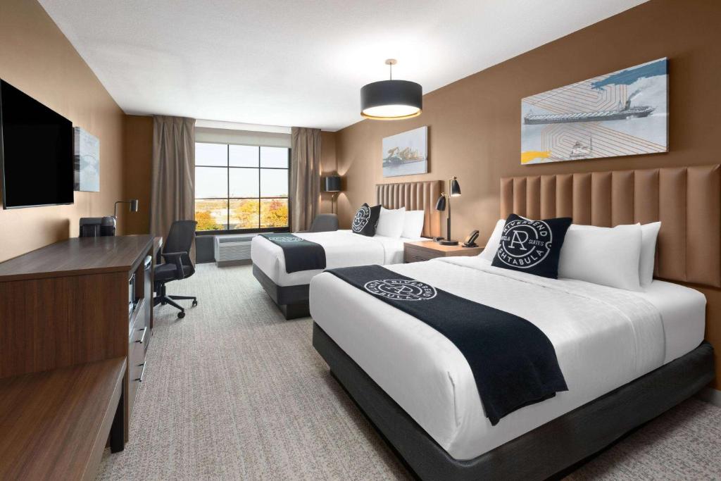 Ein Bett oder Betten in einem Zimmer der Unterkunft Riverbend Hotel and Suites, Trademark Collection by Wyndham