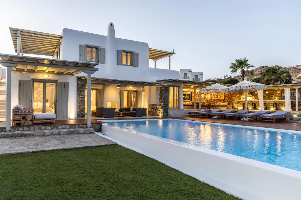 a villa with a swimming pool at dusk at Villa Assa -Mykonos in Mýkonos City