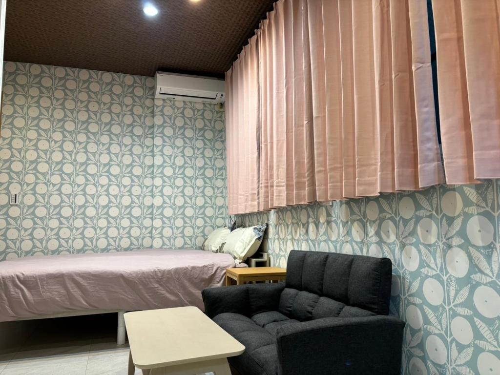 a room with a bed and a couch and a chair at Platinum Yasaka in Kyoto