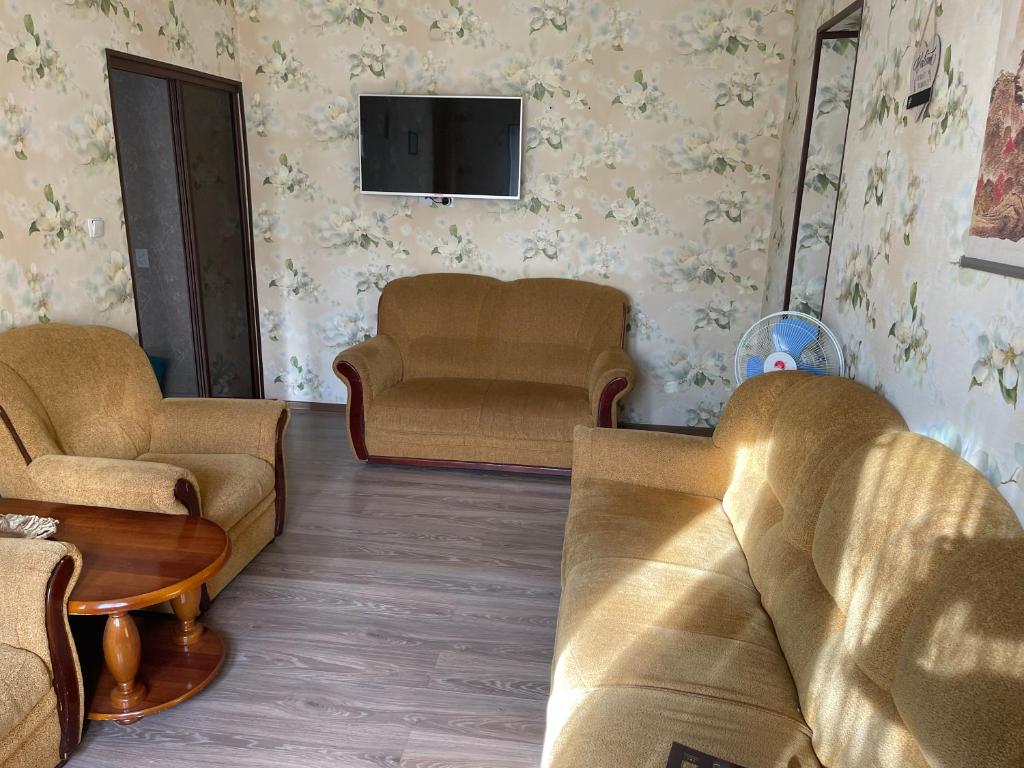a living room with two couches and a tv at Апартамент зал спальня кухня in Yunusobod