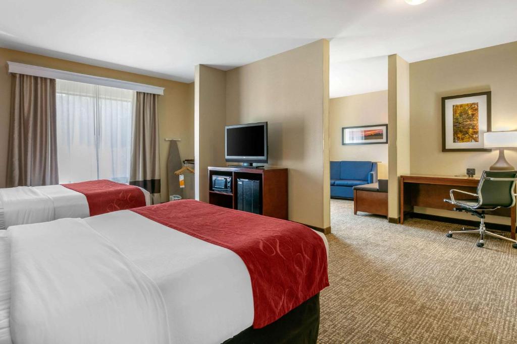 a hotel room with two beds and a flat screen tv at Comfort Suites in Forrest City