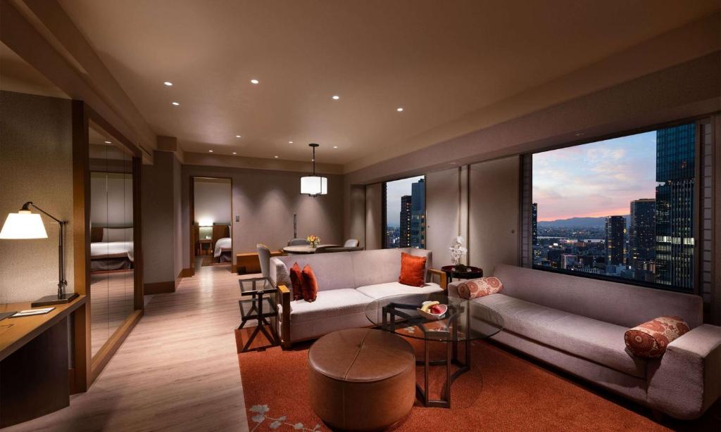 a living room with a couch and a large window at Hilton Osaka Hotel in Osaka