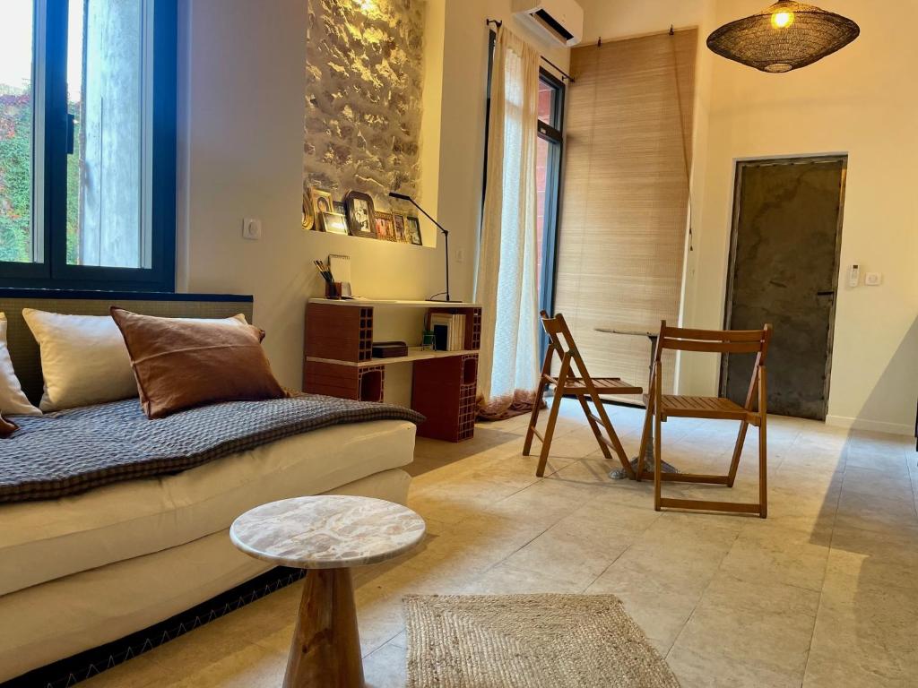 a living room with a couch and a table at "La Forge" avec parking privé in Sète