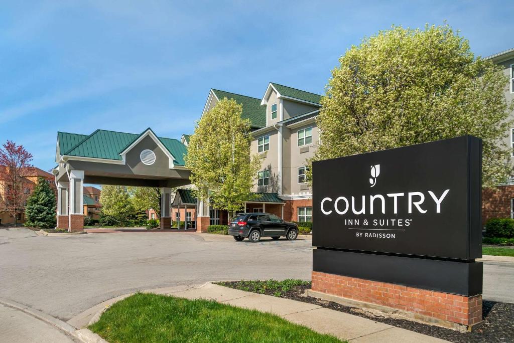a sign in front of a building with a county inn and suites at Country Inn & Suites by Radisson, Rossford - Toledo South in Rossford