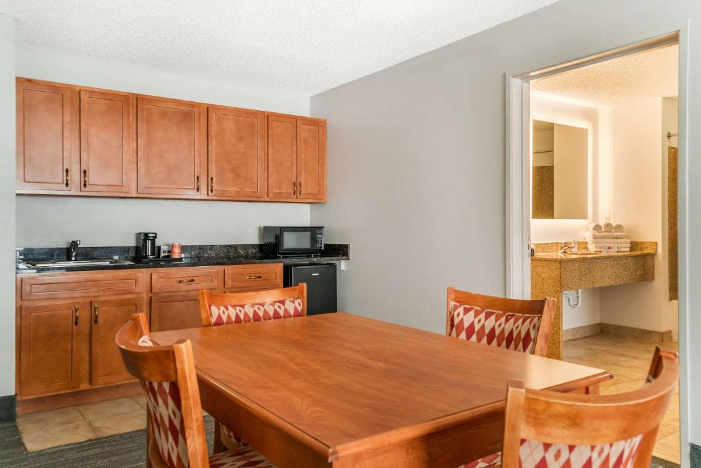 a kitchen with a wooden table and wooden cabinets at Country Inn & Suites by Radisson, Rossford - Toledo South in Rossford