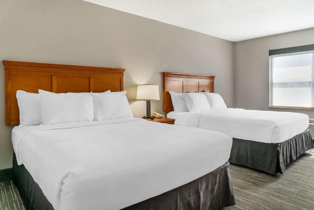 a hotel room with two beds and a window at Country Inn & Suites by Radisson, Rossford - Toledo South in Rossford