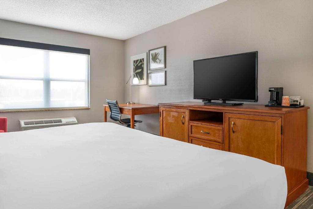 a bedroom with a bed and a flat screen tv at Country Inn & Suites by Radisson, Rossford - Toledo South in Rossford