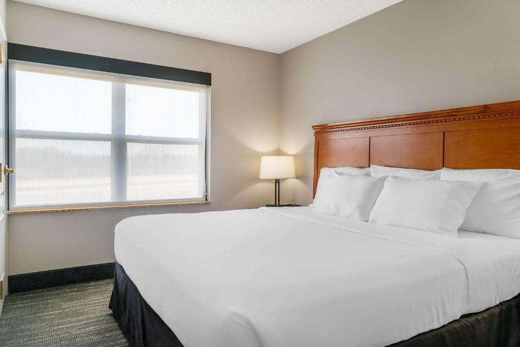 a large white bed in a room with a window at Country Inn & Suites by Radisson, Rossford - Toledo South in Rossford