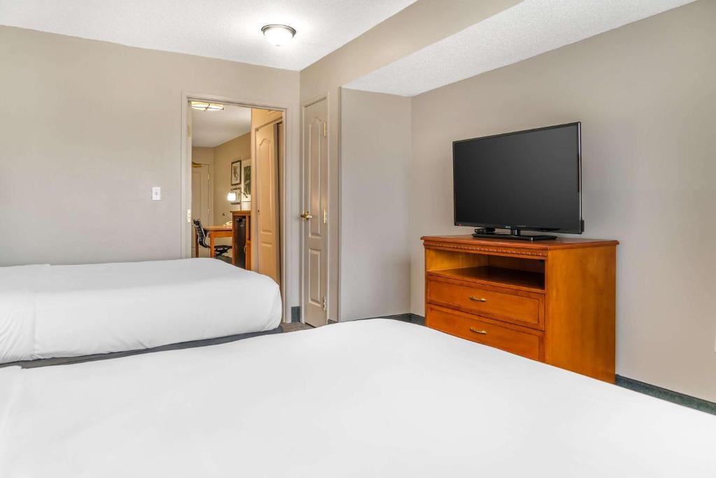a bedroom with two beds and a flat screen tv at Country Inn & Suites by Radisson, Rossford - Toledo South in Rossford