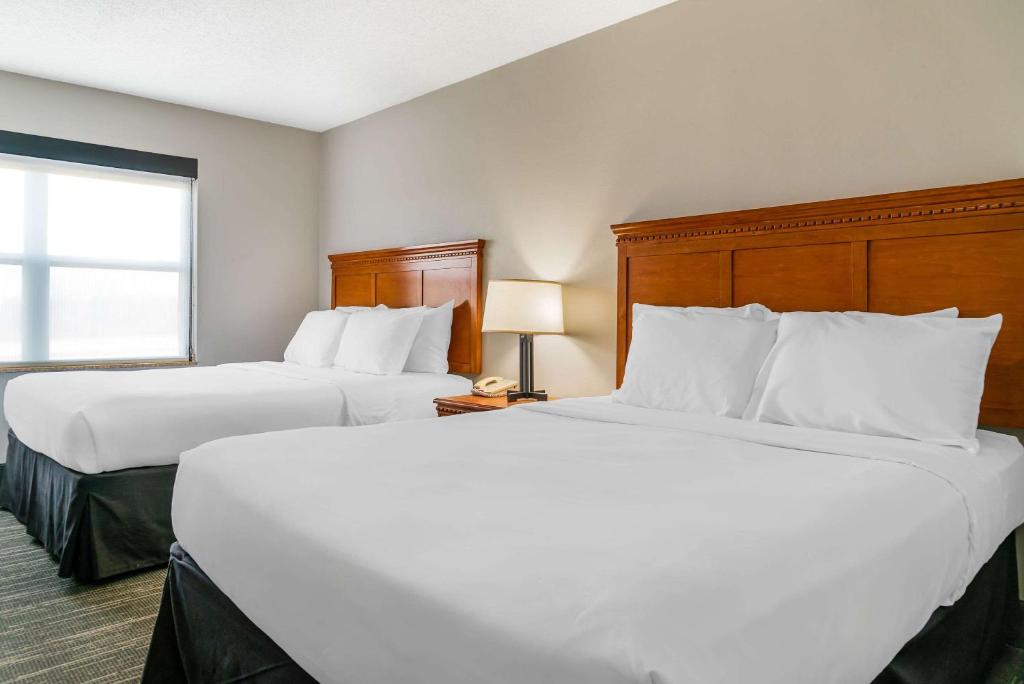 a hotel room with two beds and a window at Country Inn & Suites by Radisson, Rossford - Toledo South in Rossford
