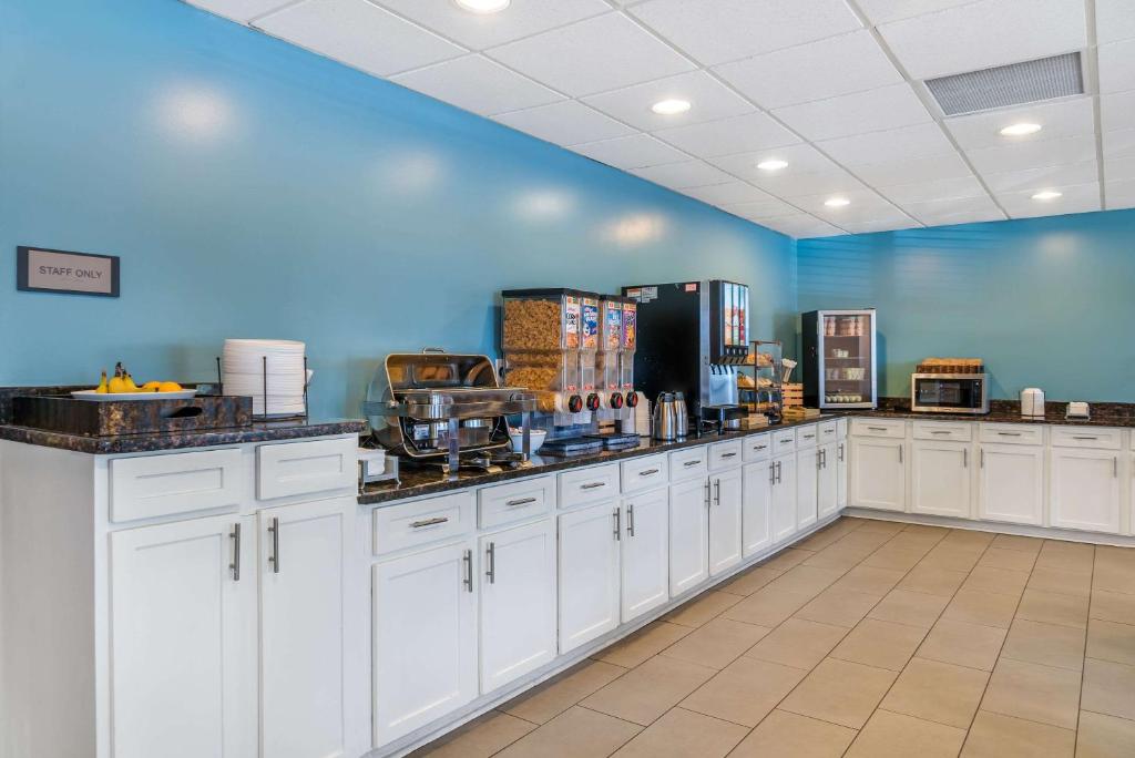 a large kitchen with white cabinets and a blue wall at Country Inn & Suites by Radisson, Rossford - Toledo South in Rossford